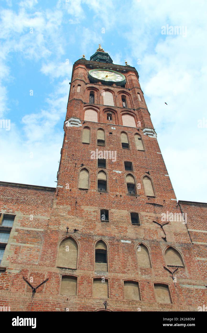 Antiker roter Backsteinturm mit Wanduhr in Danzig. Architektur des Stadtgebäudes Stockfoto