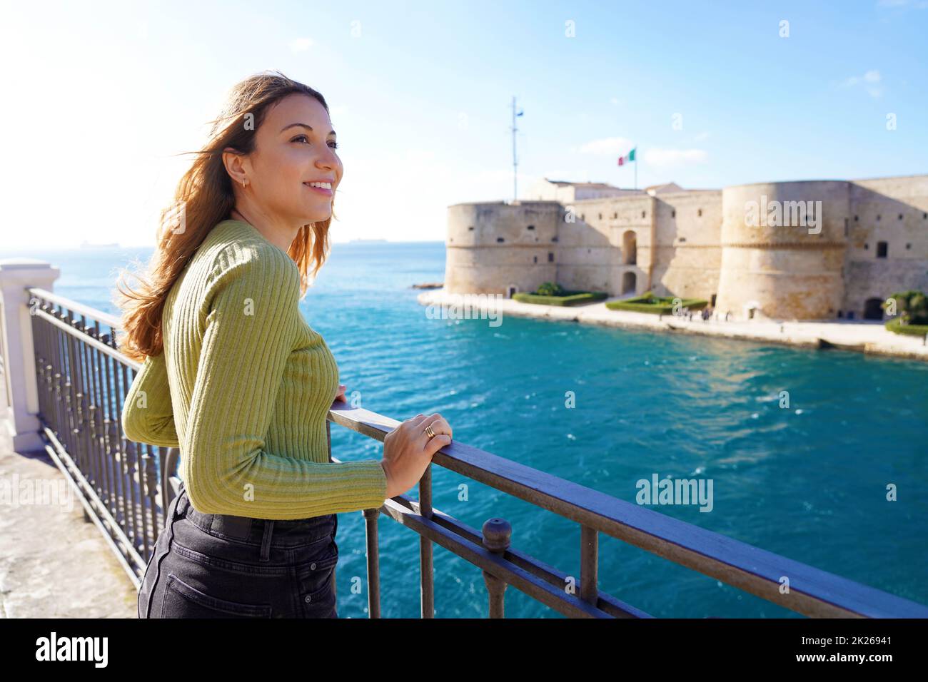 Porträt eines lächelnden entspannten Reisenden Frau Blick Taranto Stadt von der Küste, Apulien, Italien Stockfoto