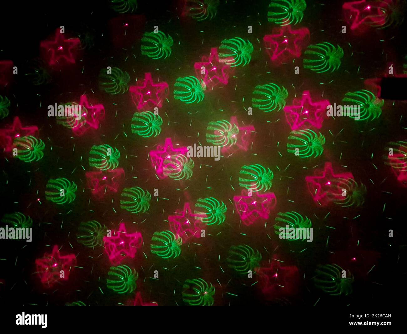 Wunderschöne Aufnahme von Laserlichtern mit Stern- und Feuerwerkskörpern an der Wand Stockfoto
