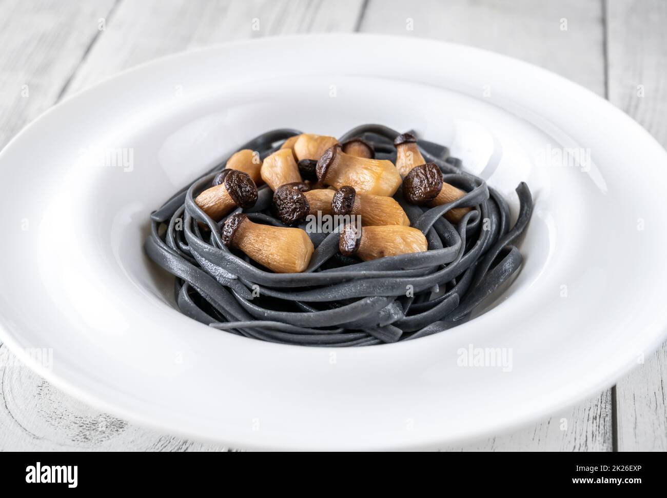 Schwarze Pasta mit Babypilzen Stockfoto