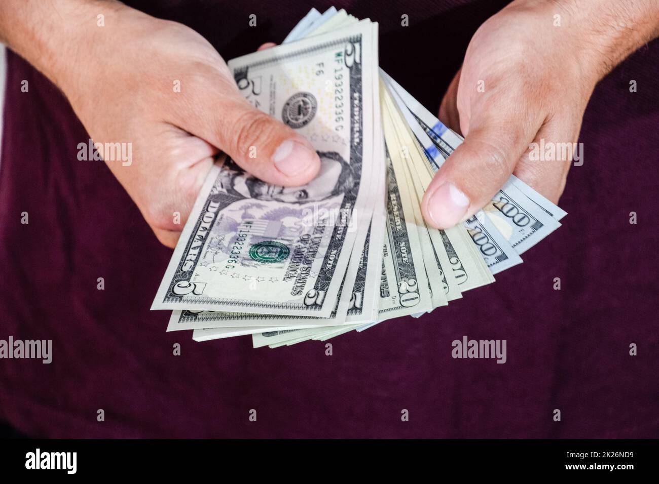 Der Mann hält einen Haufen Dollar in der Hand. US-Dollar Stockfoto