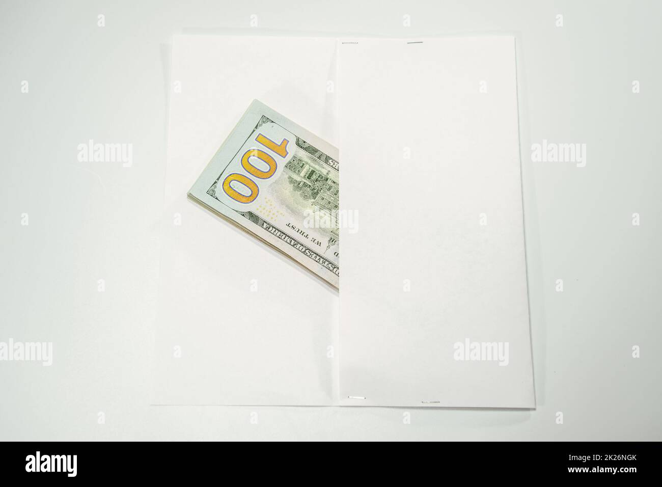 Dollars in einem Gegenwind auf weißem Hintergrund, eine Menge Geld in einem Umschlag. Stockfoto