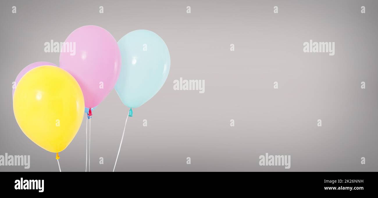 Urlaub helium Luftballons auf grauem Hintergrund isoliert, Geburtstag Konzept Stockfoto