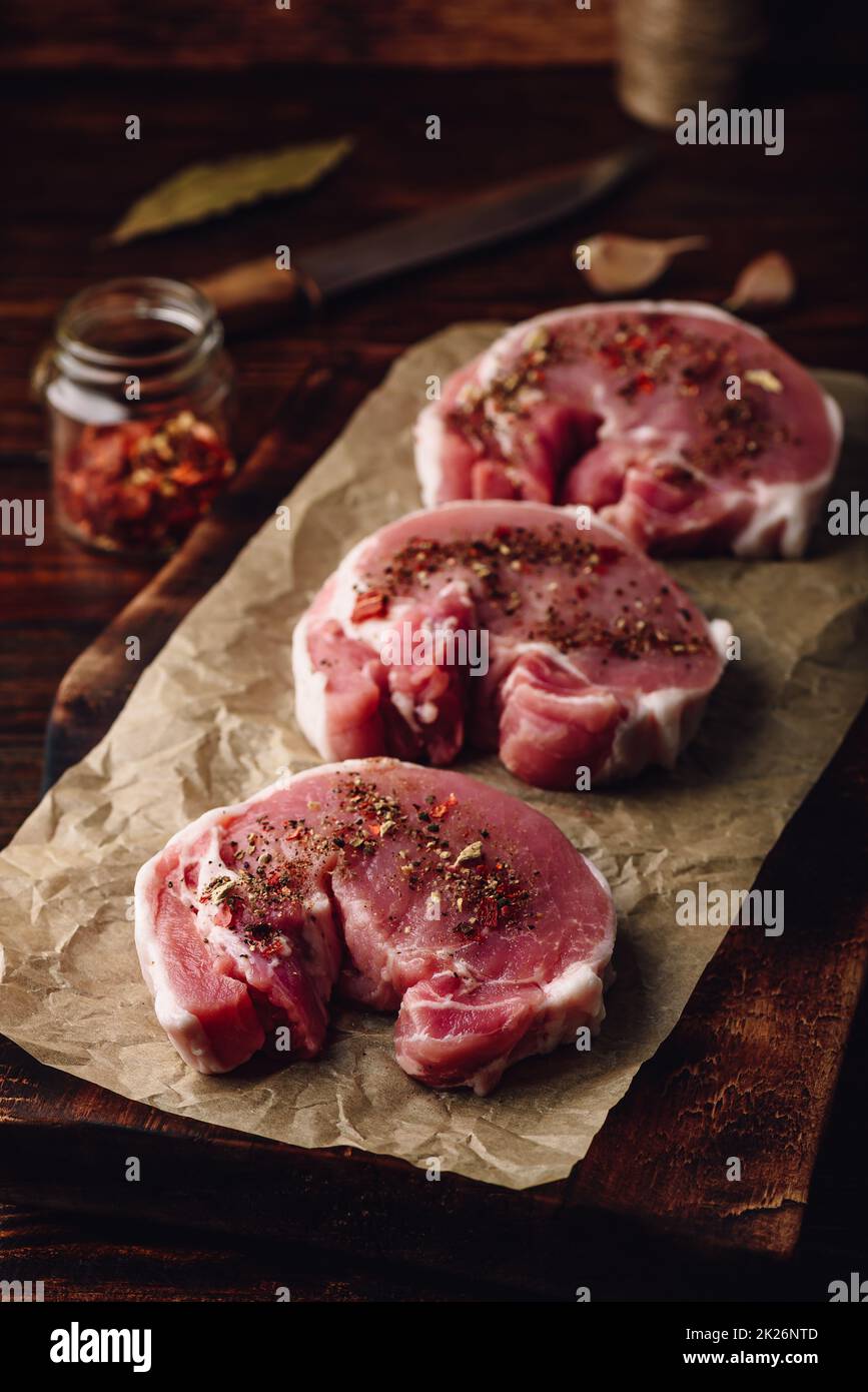 Raw Schweinelende Steaks mit verschiedenen Gewürzen Stockfoto