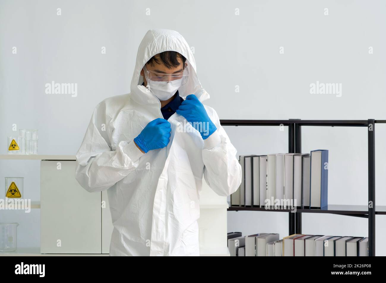 Asiatischer Wissenschaftler mit Gesichtsmaske in Virusschutzkleidung vor Beginn des Experiments in einem wissenschaftlichen Labor. Stockfoto