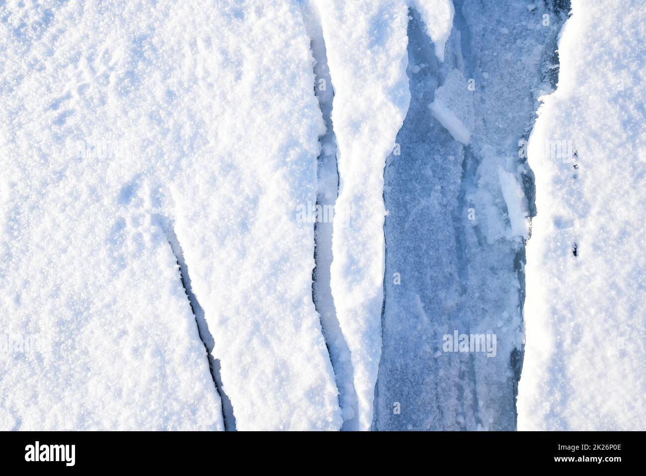 Nahaufnahme Risse auf dem Eis, das mit Schnee bedeckt ist. Baikalsee, Russland Stockfoto