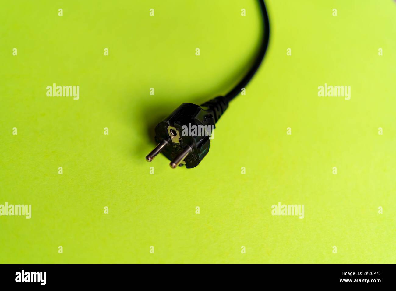 Schwarzer Stecker auf grünem Hintergrund Stockfoto