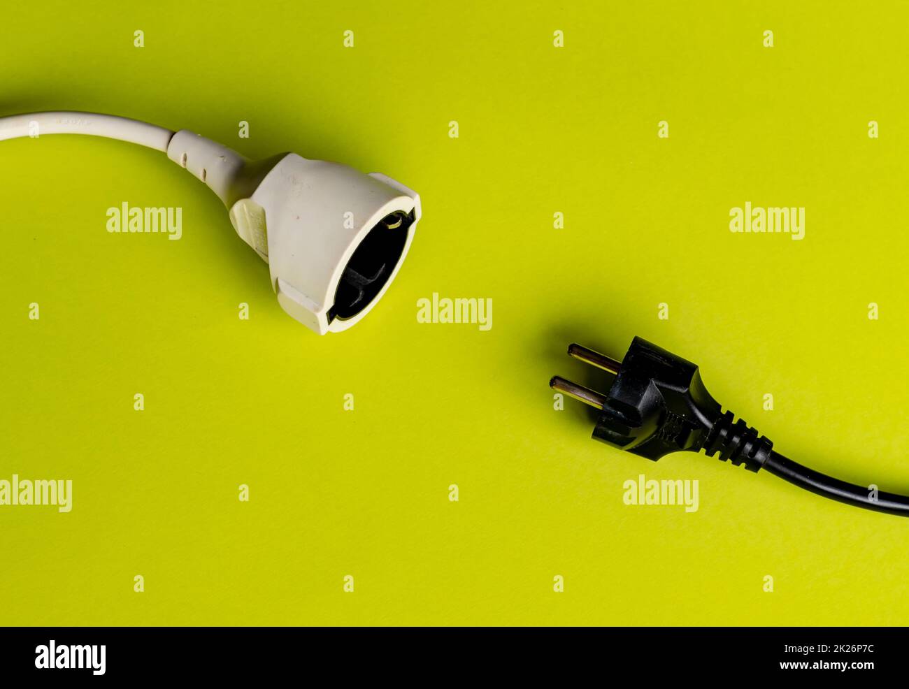 Schwarzer Stecker und weiße Buchse zeigen sich auf grünem Hintergrund Stockfoto