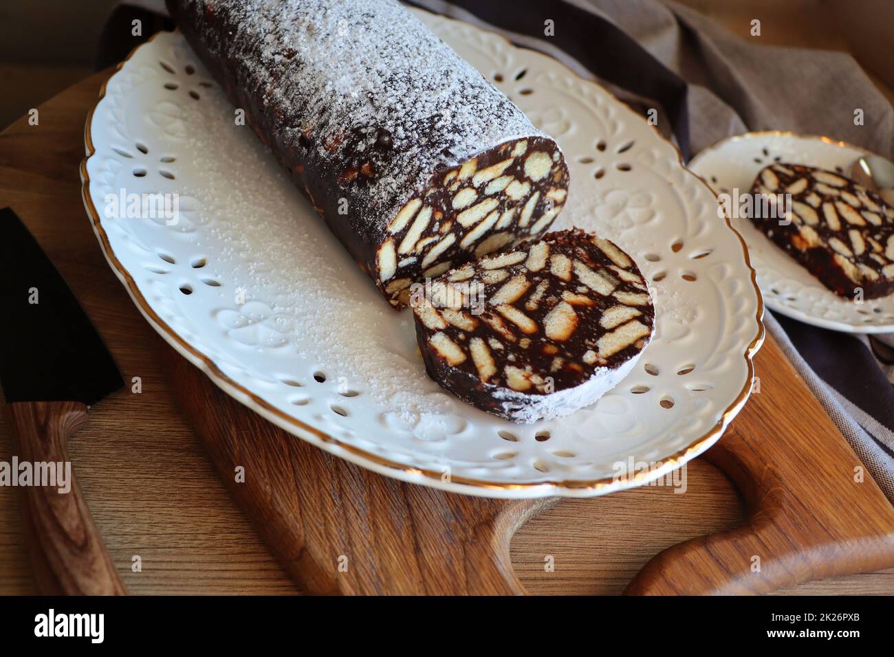 Fauler Kuchen oder Mosaikkuchen . Hausgemachter, nicht gebackener Schokoladenkuchen auf einem Holztisch Stockfoto