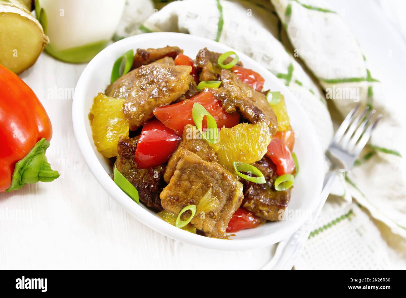 Fleisch mit Orangen in der Schüssel auf Holzbrett Stockfoto