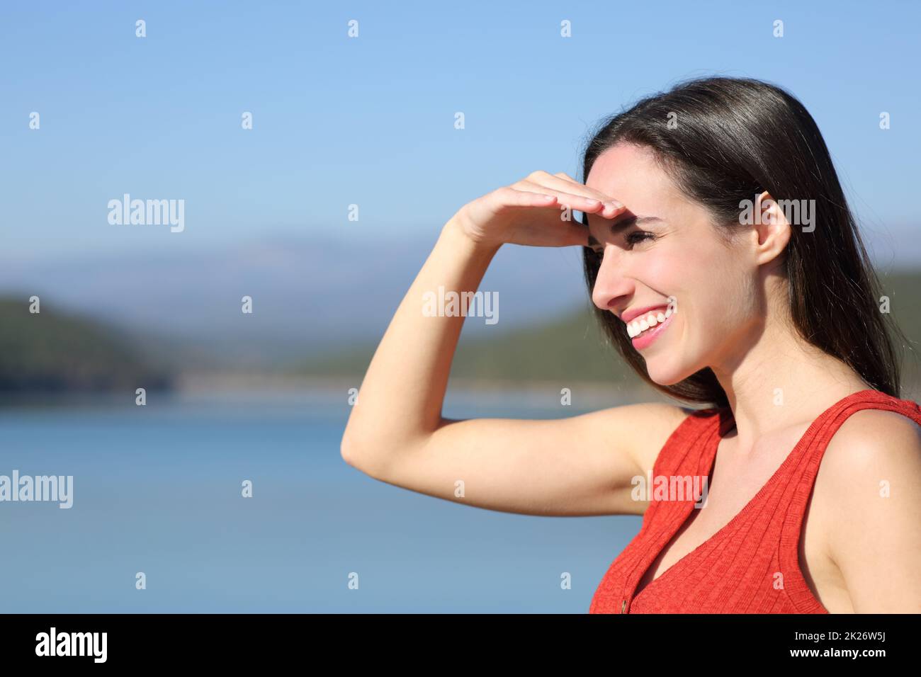 Eine Frau, die die Augen verdeckt, an einem sonnigen Tag, auf der Suche in der Natur Stockfoto