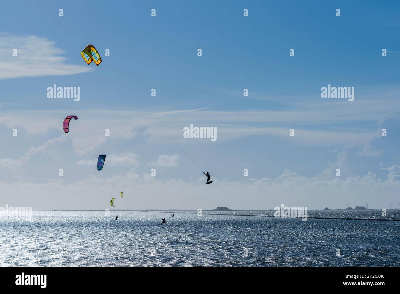 Kitesurfen an der Nordsee bei Lüttmoorsiel, Hallig Nordstrandischmoor am Horizont, Nrth Frisia, Norddeutschland Stockfoto