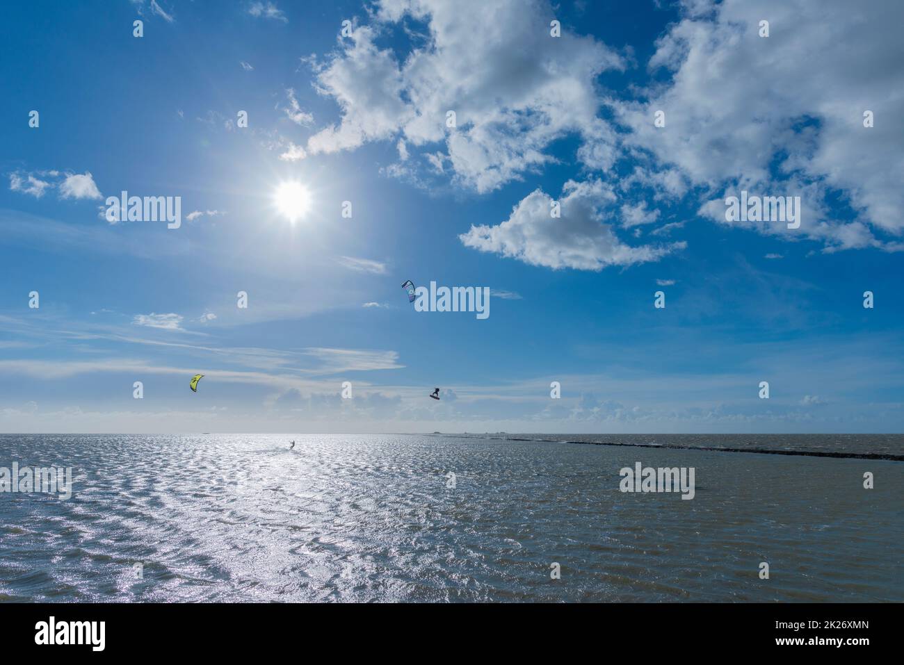 Kitesurfen an der Nordsee bei Lüttmoorsiel, Hallig Nordstrandischmoor am Horizont, Nrth Frisia, Norddeutschland Stockfoto