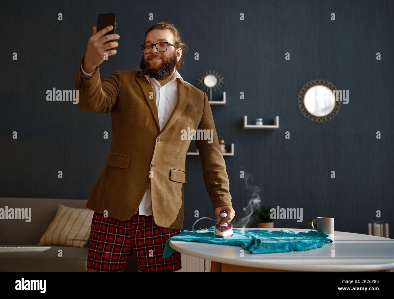 Geschäftsmann mit Telefon Video Chat Bügeln Kleidung Stockfoto