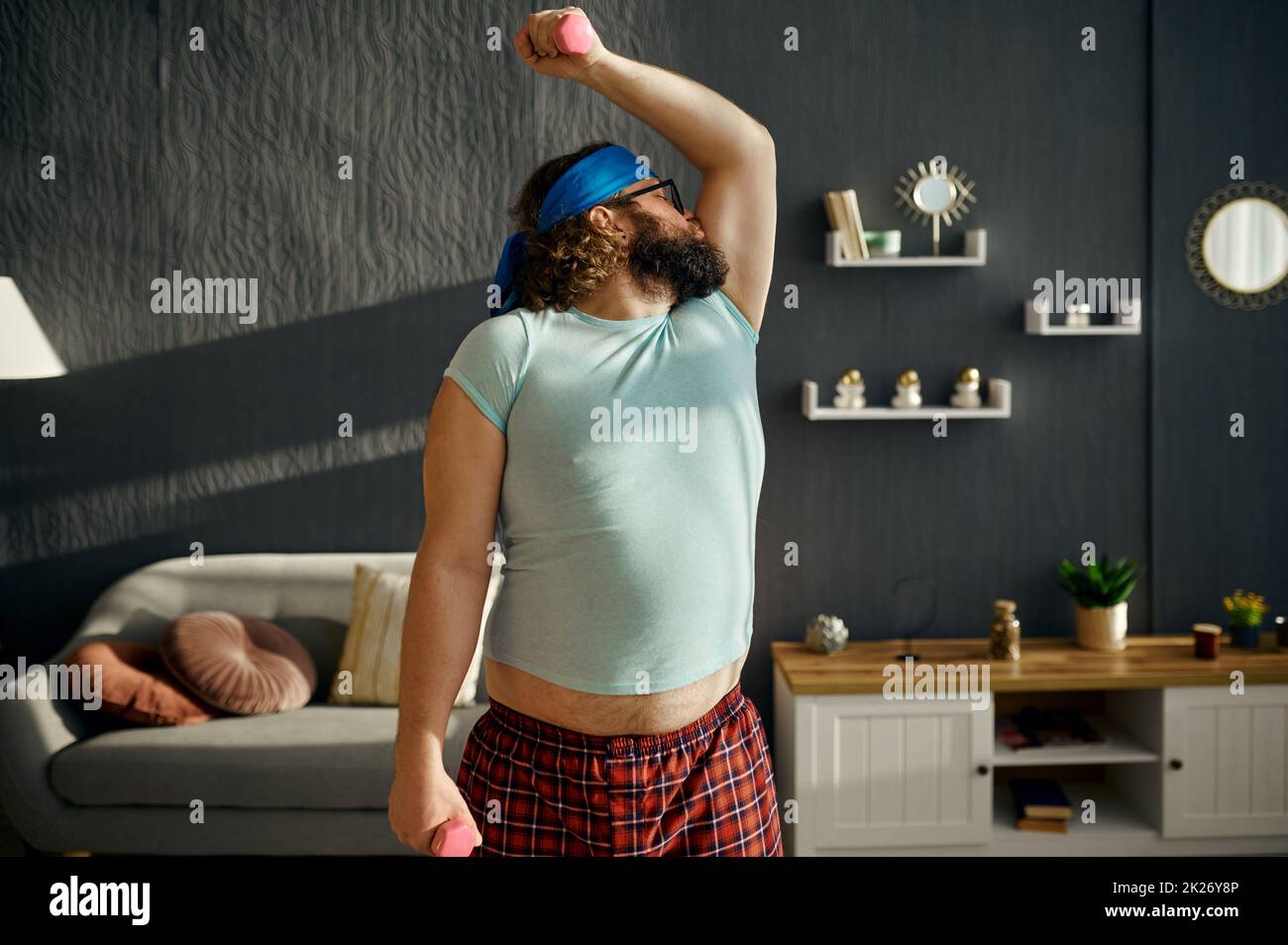 Comic serious Fat Mann Ausübung mit Gewichten Stockfoto