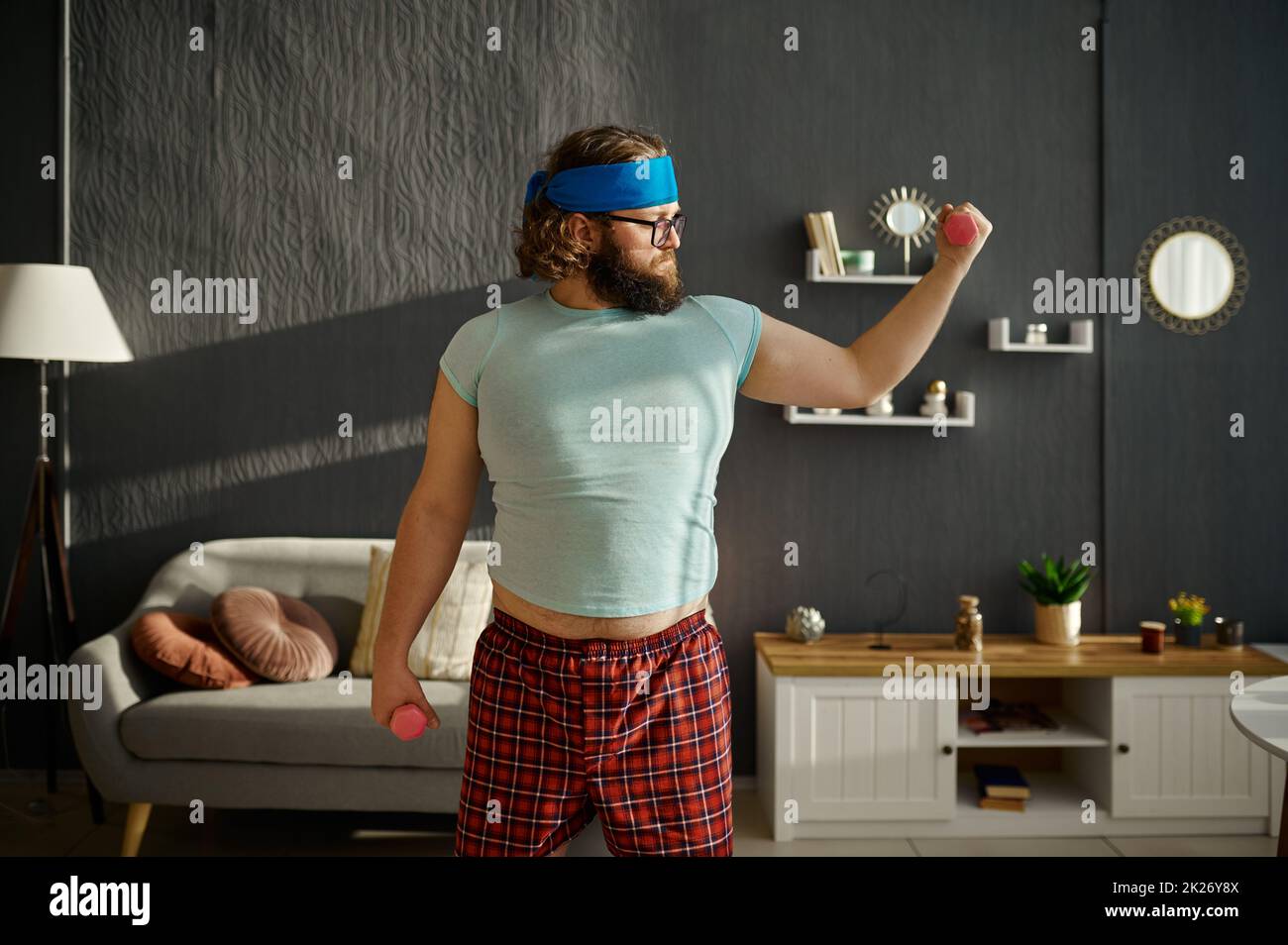 Comic serious Fat Mann Ausübung mit Gewichten Stockfoto