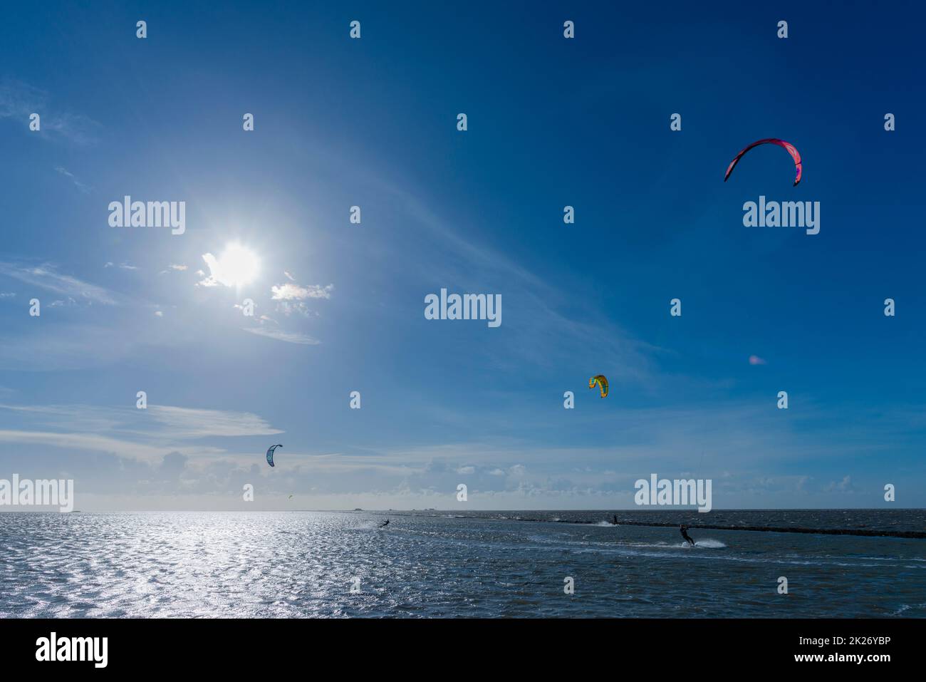 Kitesurfen an der Nordsee bei Lüttmoorsiel, Hallig Nordstrandischmoor am Horizont, Nrth Frisia, Norddeutschland Stockfoto