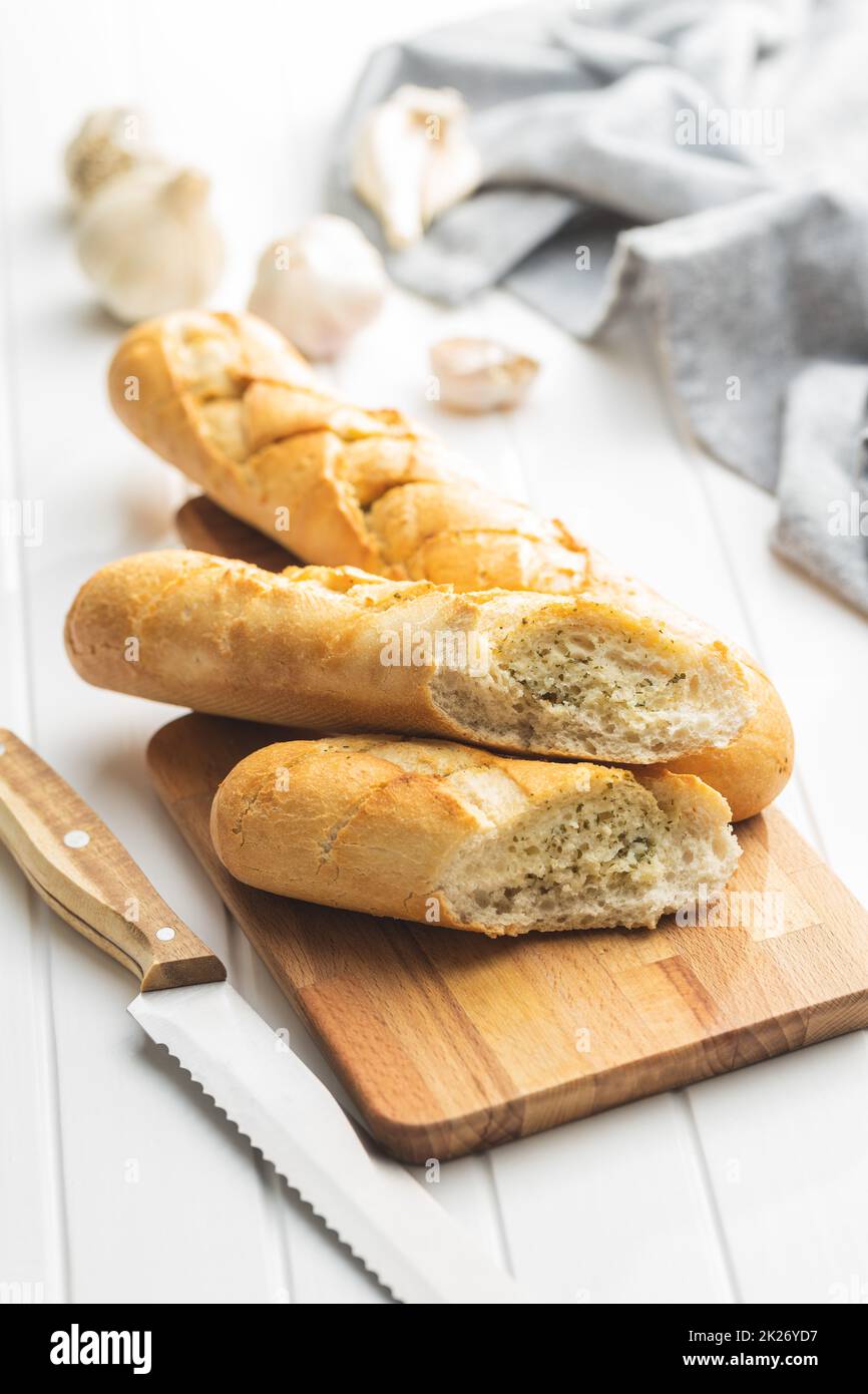 Gebratenes Baguette mit Knoblauchbutter. Knuspriges Knoblauchbrot auf einem weißen Tisch. Stockfoto