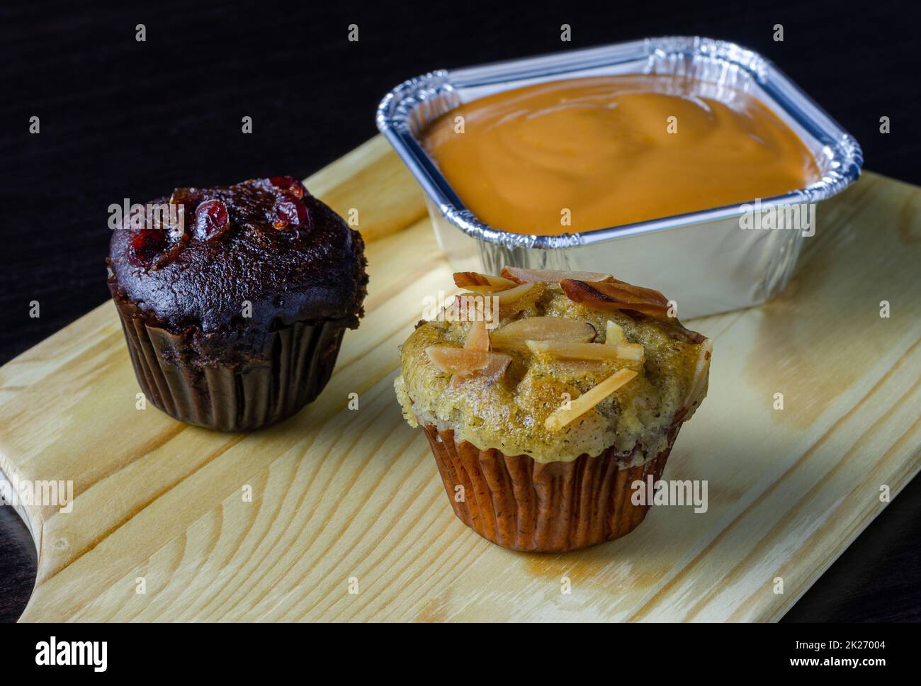 Schokoladen-Muffin, Bananen-Cupcake und Milch-Tee-Fudge-Kuchen auf einem Holztablett. Stockfoto