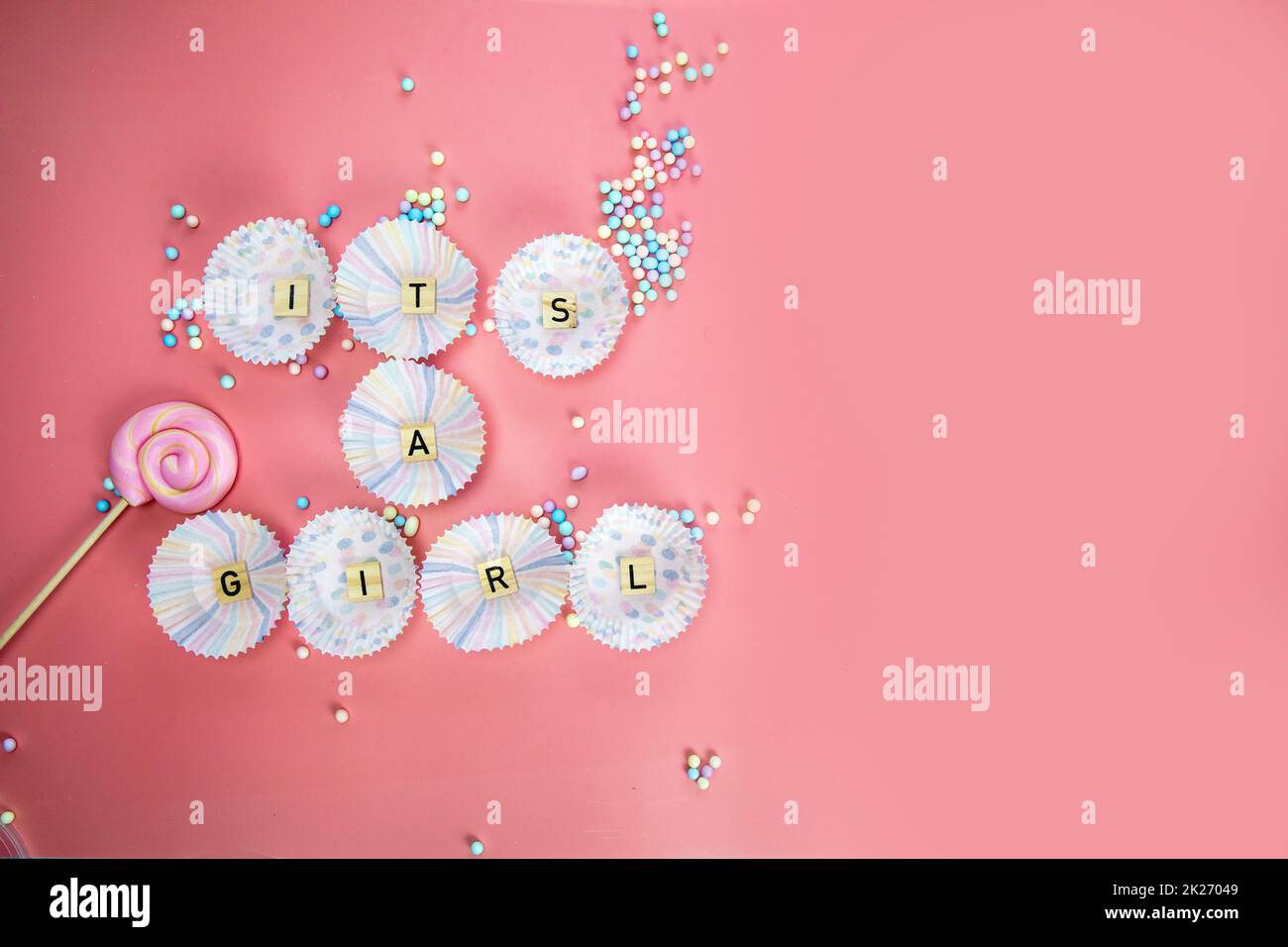 Es ist eine Grußkarte mit Girl Text auf Holzhintergrund mit pinkfarbenen Federn für Babys oder Neugeborene, Ansage-Grußkarte für Mädchen, Draufsicht in bunten Pastelltönen Stockfoto