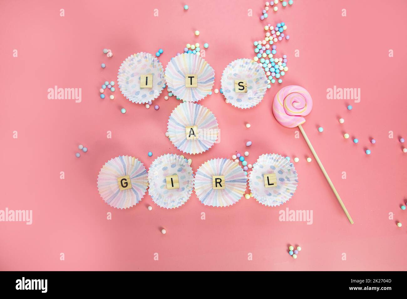 Es ist eine Grußkarte mit Girl Text auf Holzhintergrund mit pinkfarbenen Federn für Babys oder Neugeborene, Ansage-Grußkarte für Mädchen, Draufsicht in bunten Pastelltönen Stockfoto