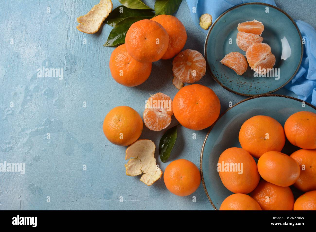 Frische Mandarinenfrüchte mit Blättern aus dem Obstgarten. Gartenarbeit im Haus. Organische Mandarine ganz und Scheiben. Orange Farbe. Stockfoto