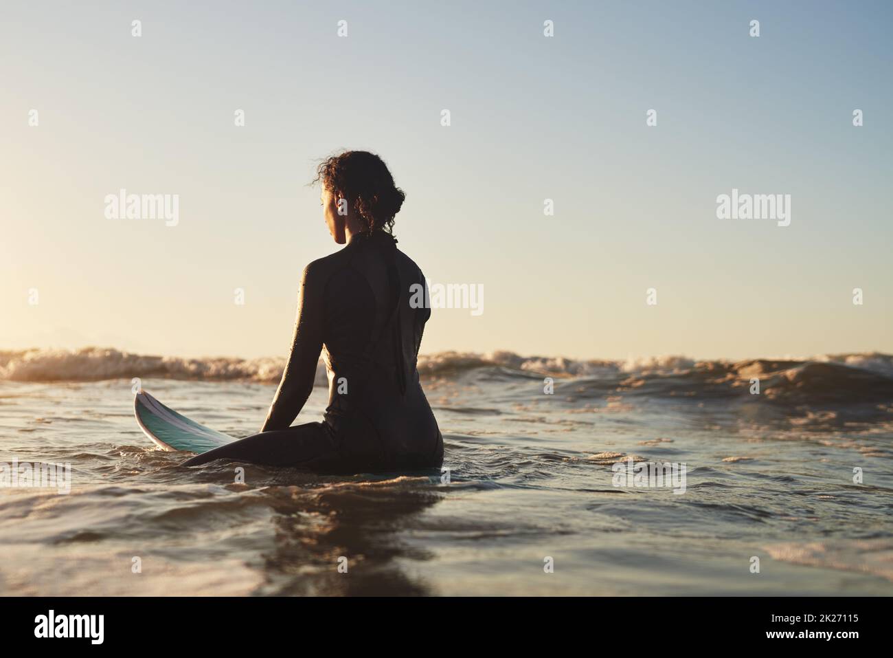 Sie ist so ruhig wie der Ozean. Rückansicht einer jungen Frau, die im Meer surft. Stockfoto