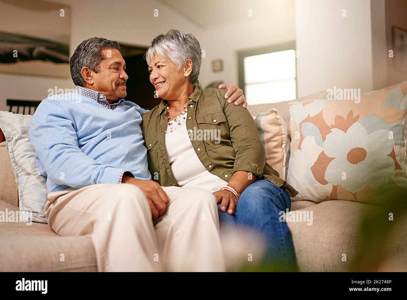 Ich war glücklich, dass ich danach im Ruhestand war. Aufnahme eines glücklichen älteren Paares, das sich zu Hause auf dem Sofa entspannt. Stockfoto