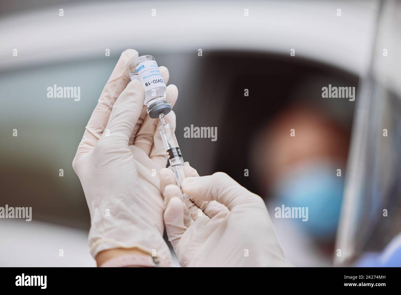Zeit, sich impfen zu lassen. Aufnahme eines nicht erkennbaren medizinischen Mitarbeiters, der mit einer Spritze Flüssigkeit aus einem Fläschchen auf einer Fahrt durch die Impfstelle extrahiert. Stockfoto