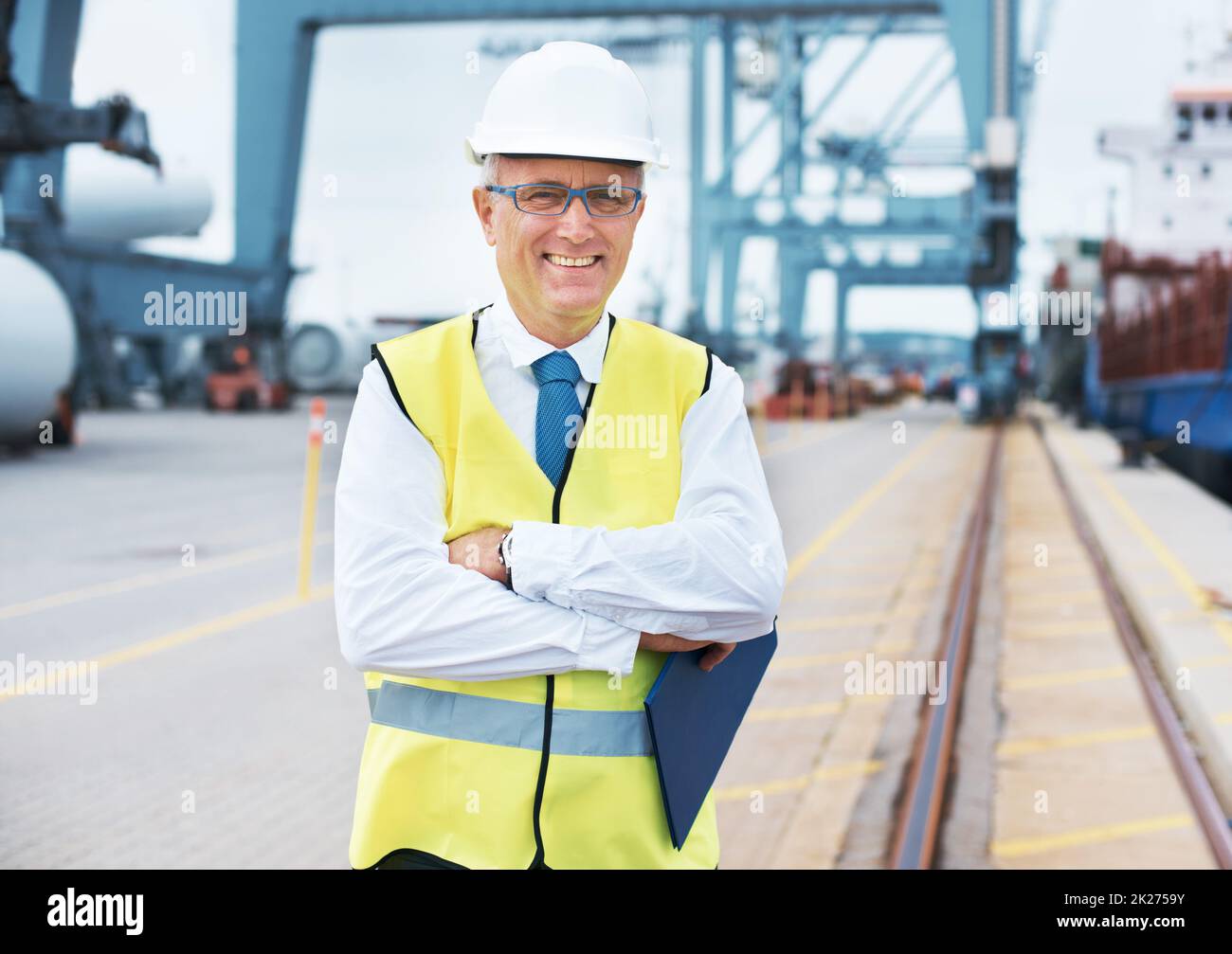 Bereit zur Umfrage. Porträt eines Hafenarbeiters, der inmitten der Schifffahrt am Hafen steht. Stockfoto