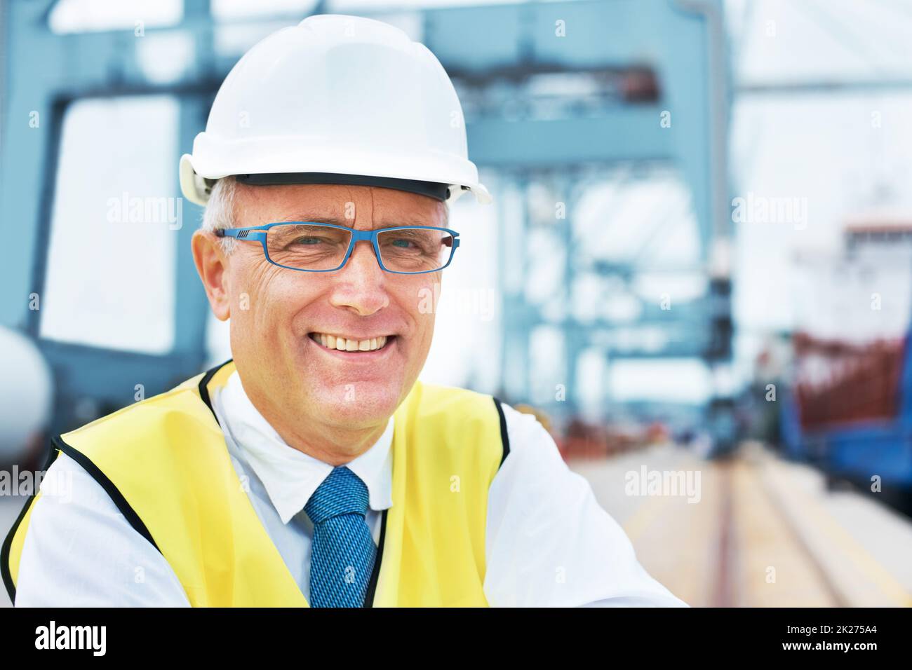 Sicherheit geht vor. Porträt eines Hafenarbeiters, der inmitten der Schifffahrt am Hafen steht. Stockfoto