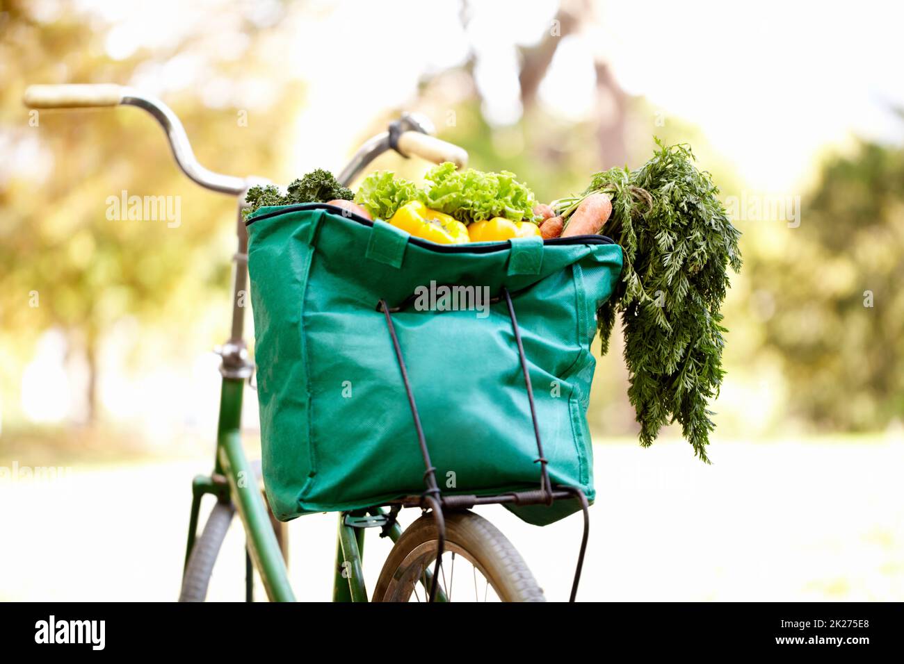 Gesunde Ernährung und Bewegung. Zugeschnittenes Bild einer Tasche mit Gemüse auf einem Fahrrad. Stockfoto