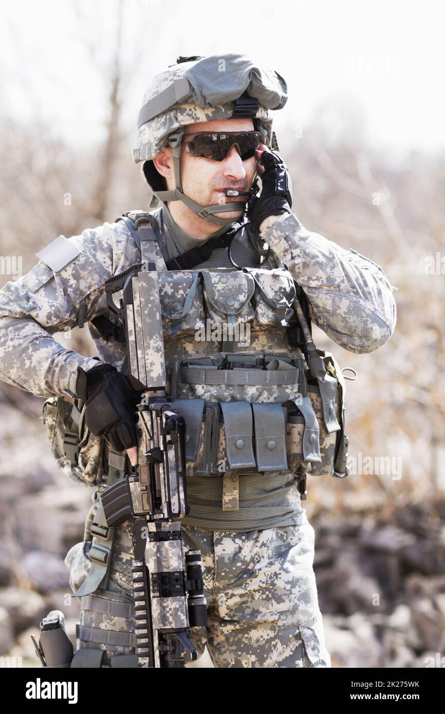 Ausgebildet in militärischer Taktik. Ein Soldat hockte sich neben einer abgebrochenen Wand und zeigte seine Waffe in die Ferne. Stockfoto