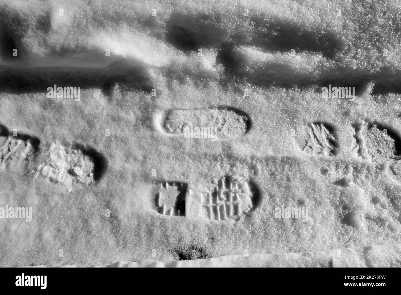 Der Schuhdruck einer Person auf Schnee, der Schuhdruck auf schwarzem und weißem Schnee Stockfoto