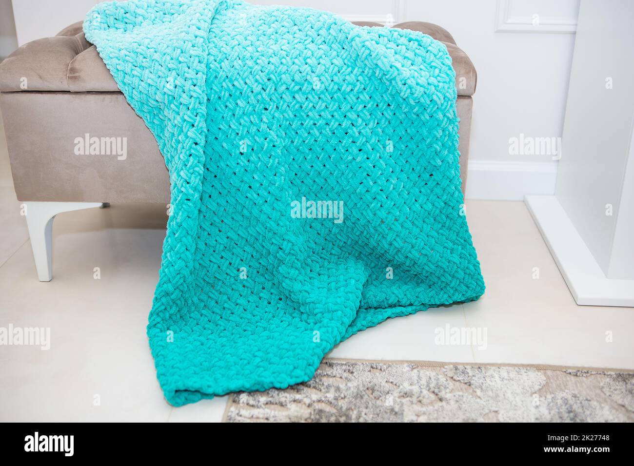 Hintergrundstruktur aus Plüschgewebe in aquamaringrüner Farbe, Hintergrundmuster aus weichem Wollmaterial auf einem kleinen Sofa, gemütliches Konzept. Stockfoto