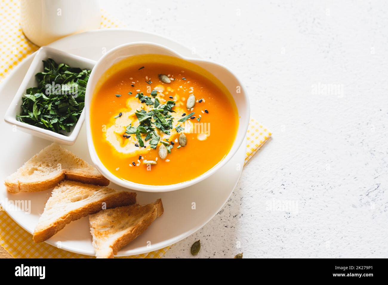 Vegetarische Herbstsuppe mit Kürbis und Karotten mit Sahne und Samen. Comfort Food, Herbst und Winter gesundes Slow Food Konzept Stockfoto
