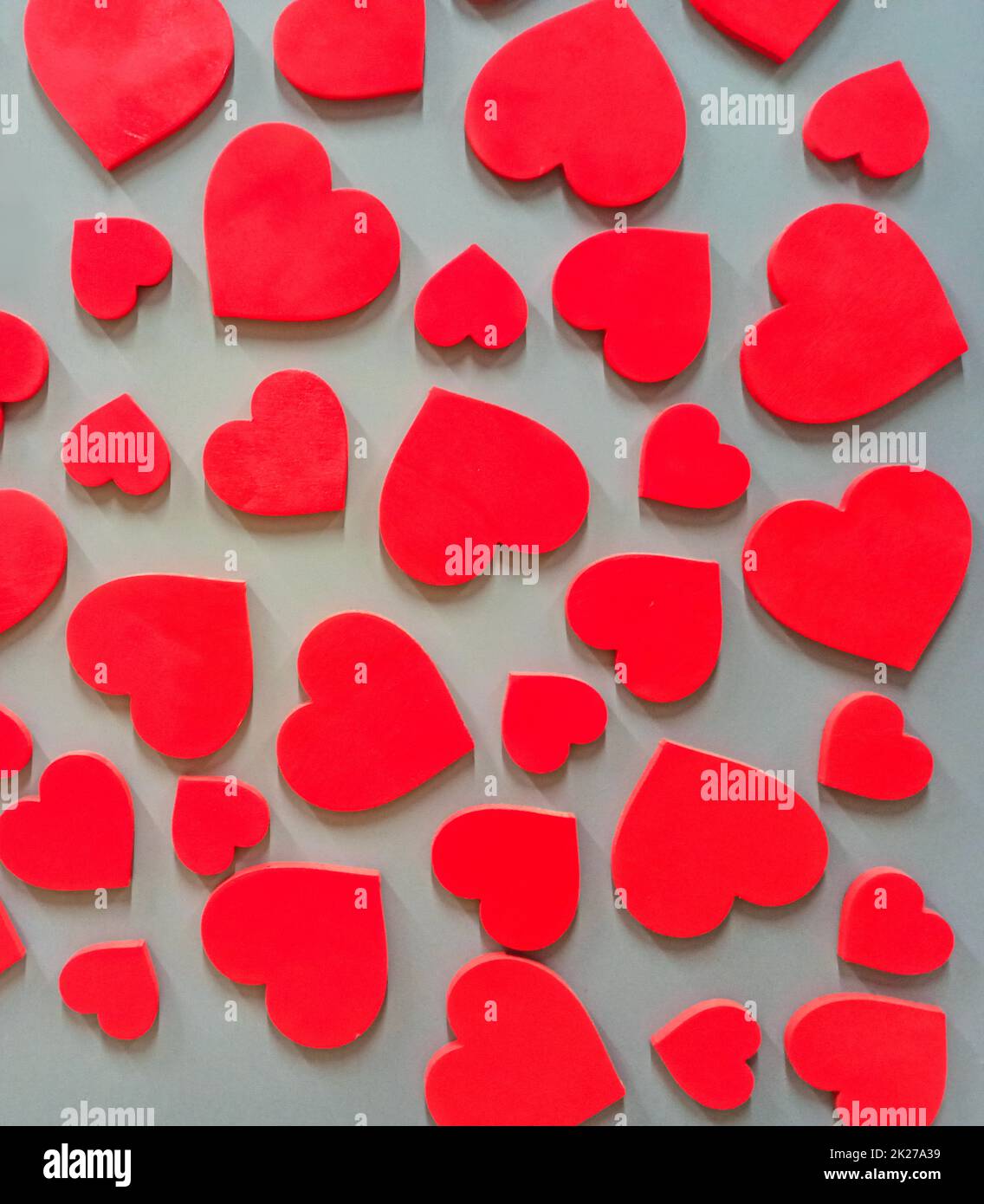 Rotes Herz hängt an einer Ziegelwand. Strukturiertes Symbol der Liebe Stockfoto