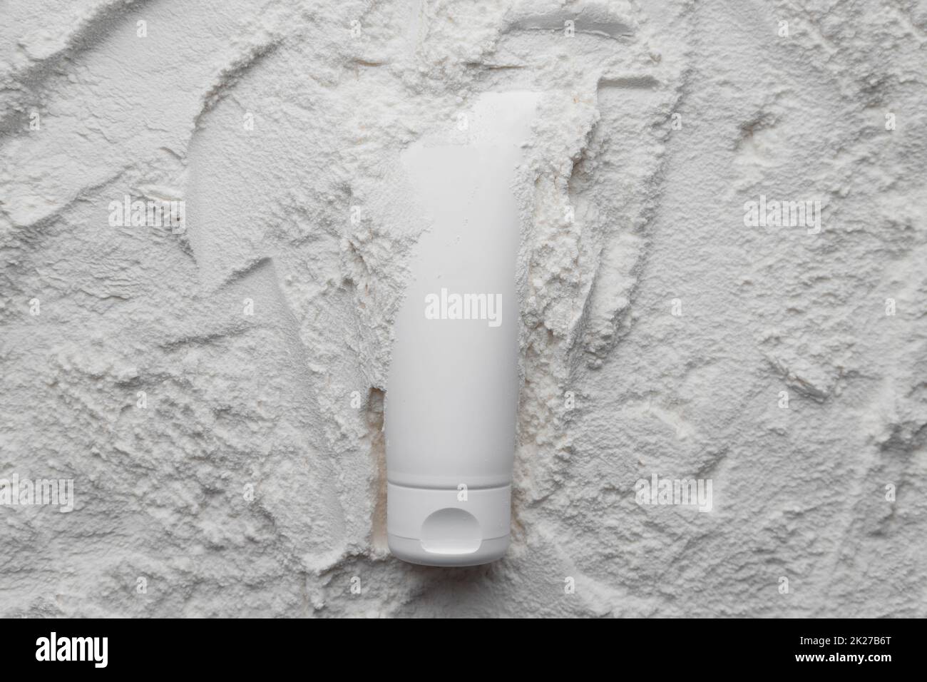 Weißes Kosmetikröhrchenmodell auf weißem Pulverhintergrund. Medizinische Hautpflege im Beauty-Spa Stockfoto