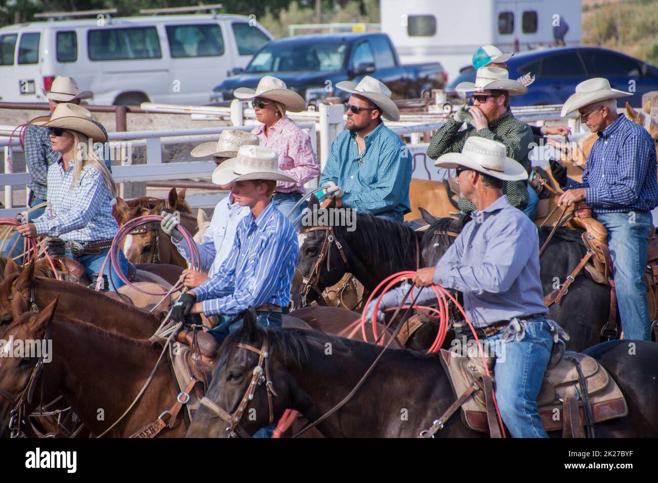 Eine Gruppe von Cowboys und Cowgirls warten bei einem Rodeo in Fruita Colorado auf ihre Pferde Stockfoto
