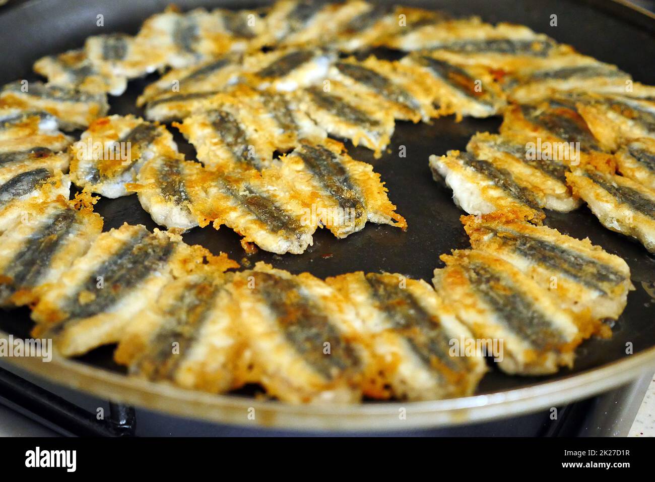 Fisch wird in der Pfanne gebraten, knusprig gebratener Fisch, Sardellenfisch kocht in der Pfanne Stockfoto