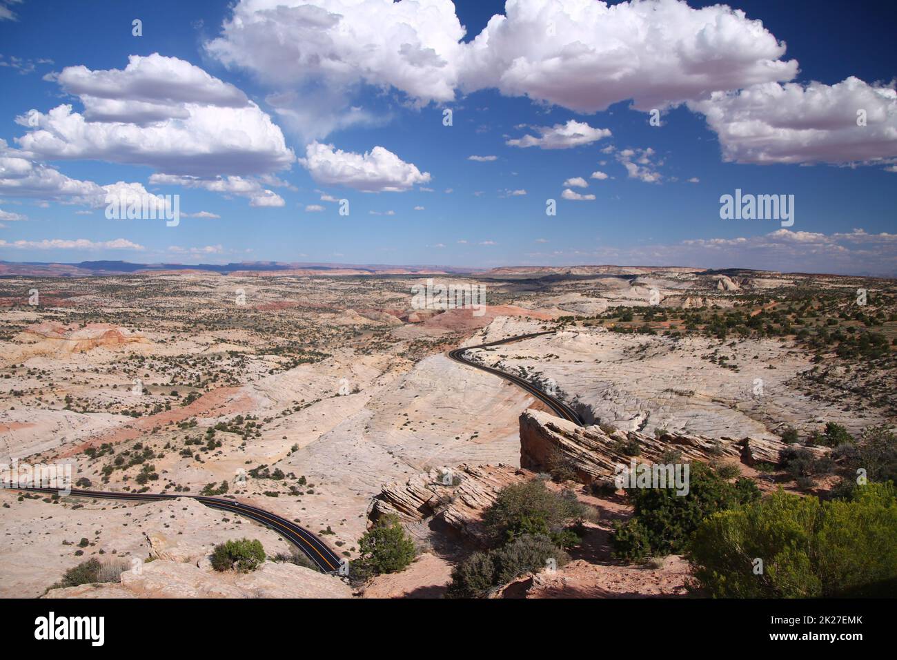 Panoramablick auf eine schwarze Asphaltstraße, die sich um rosa und rote Felsen des Capitol Reef National Park schlängelt Stockfoto