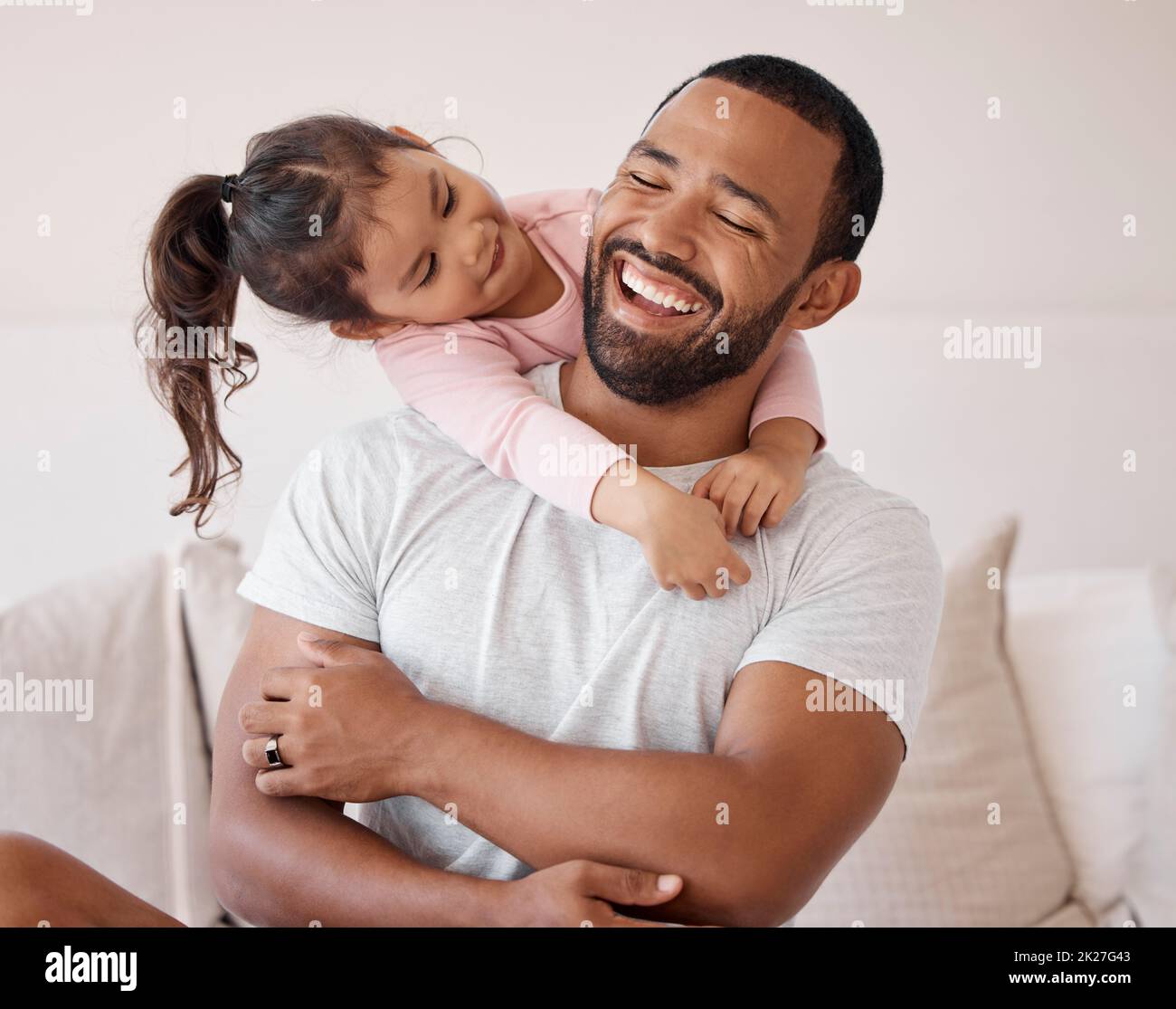 Familienumarmung, glückliche Liebe und Vater mit Lächeln für Kind auf dem Sofa zu Hause, kümmern sich um Kind und aufgeregt über ein gemeinsames Wochenende im Wohnzimmer. Mädchen Stockfoto