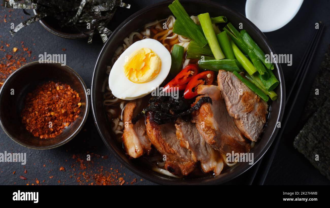 Ramen-Suppe mit hartgekochtem Ei, Gemüse, Schweinefleisch, Sojasauce. Japanischer Tonkotsu Ramen, Schweineknochenbrühe Nudeln Stockfoto