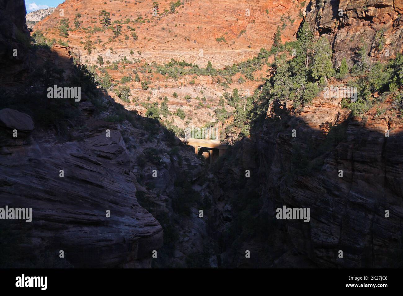 Die Brücke am Fuße der roten Felsenklippen mit Schatten im Zion-Nationalpark Stockfoto