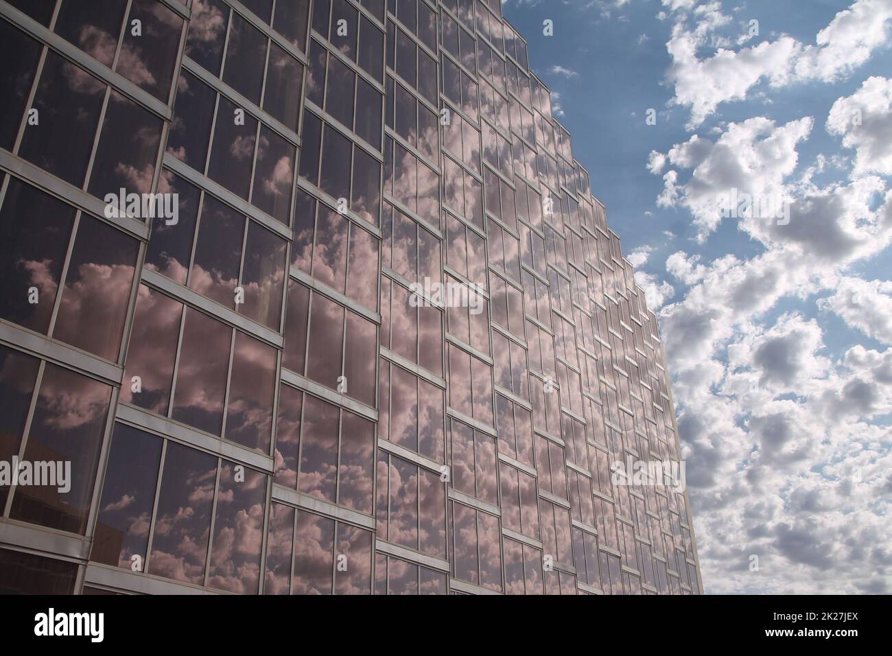 Die Schönheit der Reflexionen der Wolken in den pinkfarbenen Gläsern eines Wolkenkratzers Stockfoto