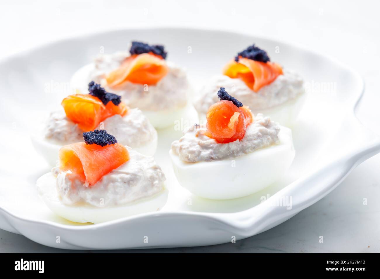 Gekochte Eier gefüllt mit Thunfisch-Aufstrich und geräuchertem Lachs und schwarzem Kaviar auf der Oberseite Stockfoto