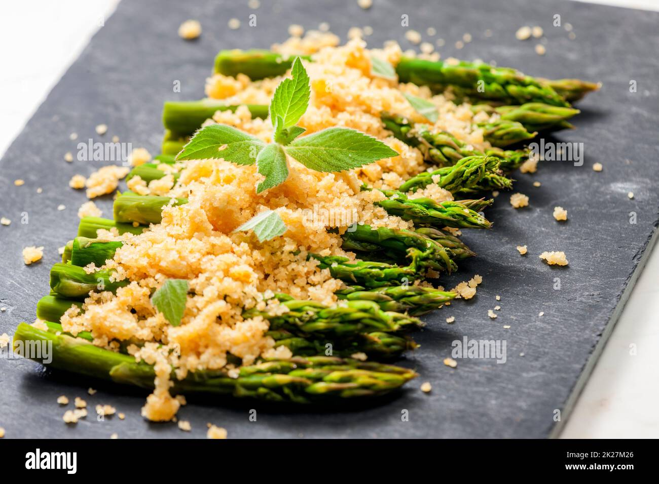 parmesan und Paniermehl auf grünem Spargel Stockfoto