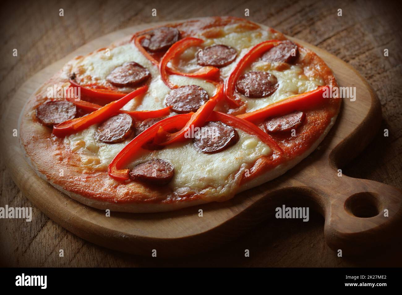 Hot hausgemachte Pizza mit Salami, paprica auf hölzernen Tisch. Ansicht von oben Stockfoto