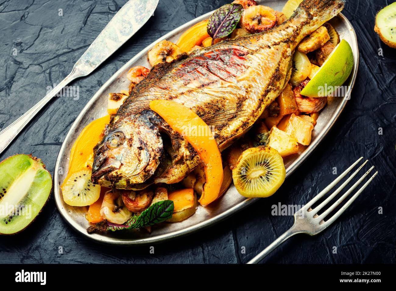 Gebackener Fisch dorado mit Ananas, Mango und Kiwi. Stockfoto