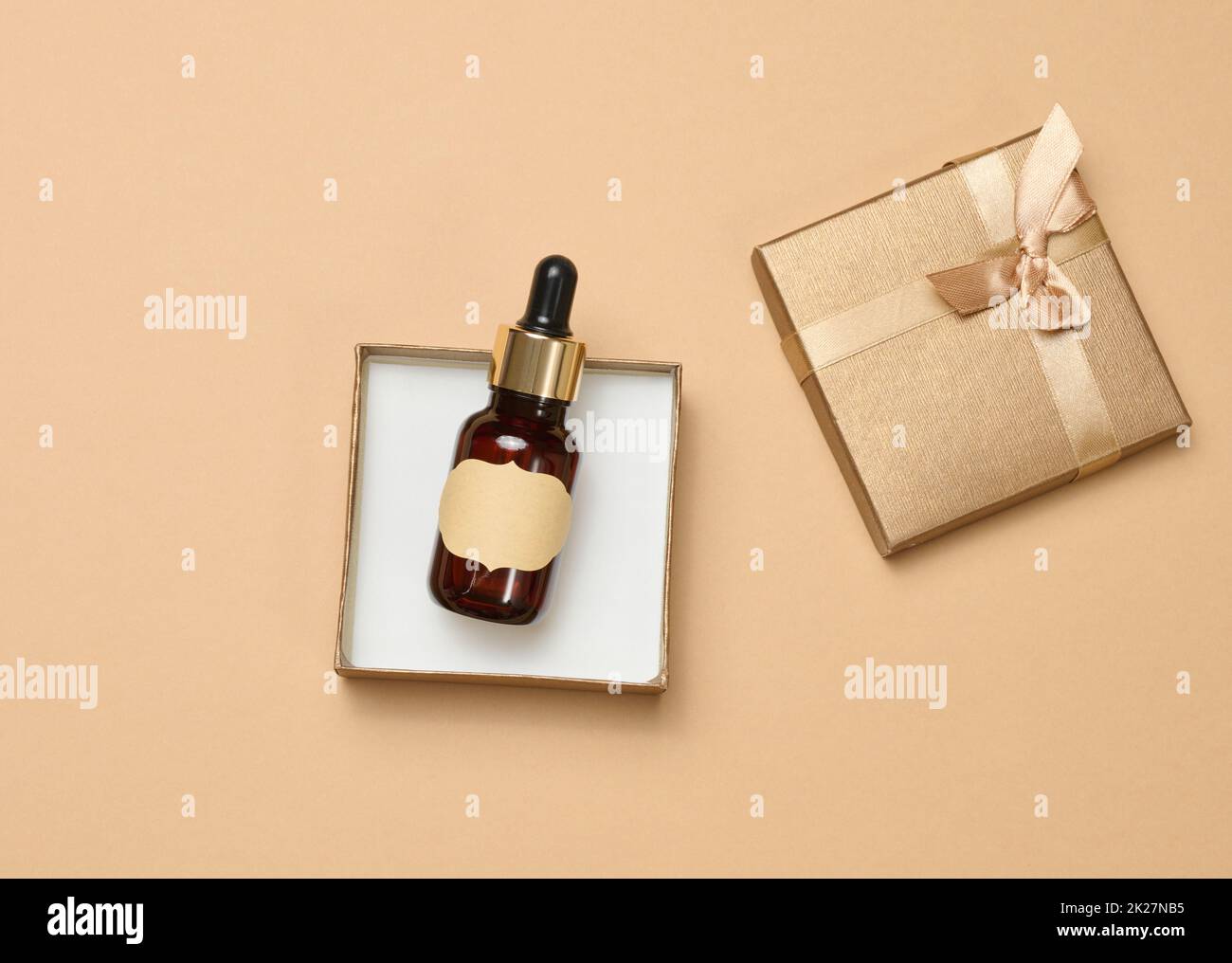 Glasflasche mit Papier leerem Etikett in einer Schachtel, Draufsicht. Behälter für Kosmetika, Aromaöle Stockfoto